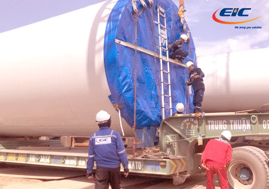 Hình ảnh giám định viên EIC đang thực hiện nghiệp vụ giám định hàng hải giai đoạn xếp hàng lên xe tải siêu trường siêu trọng, vận tải từ cảng vào bãi và hạ xuống bãi an toàn.